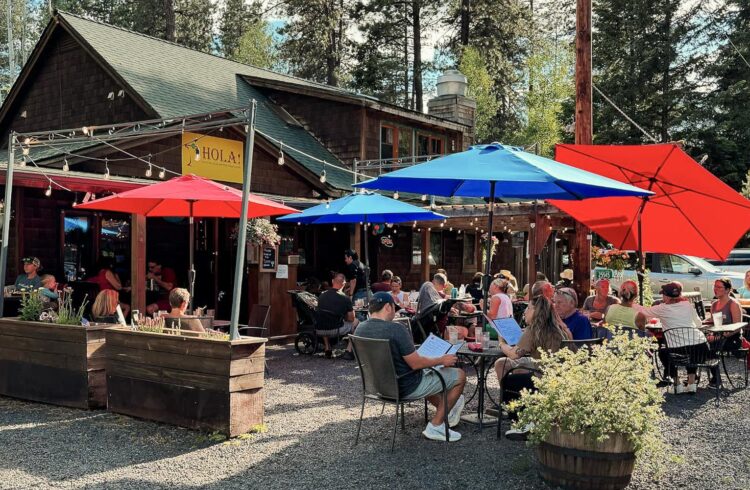 outdoor dining with tables full of guests and colorful umbrellas over tables