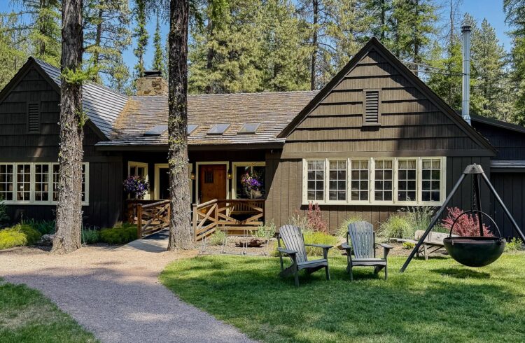 wood building on green lawn with chairs and fire pit