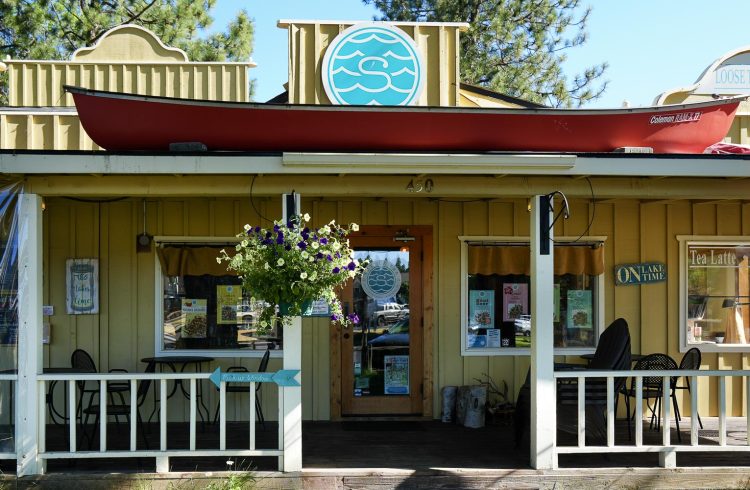 tea shop exterior with canoe on the roof and hanging flower basket