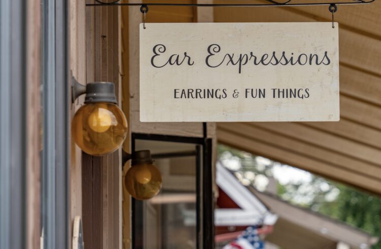 hanging sign and light fixture outside of earring shop