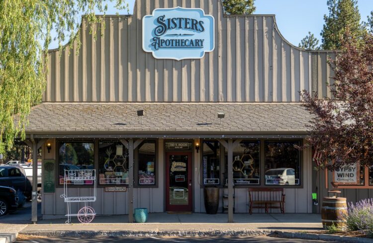 tan storefront with trees in the foreground
