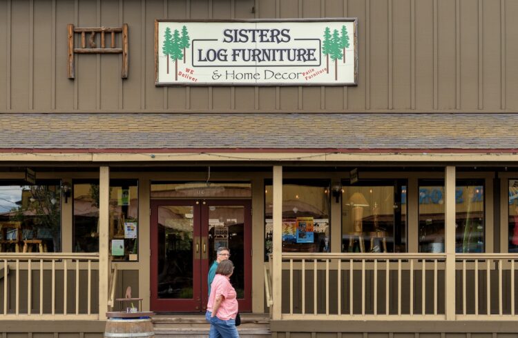 sisters log furniture storefront with porch and two customers