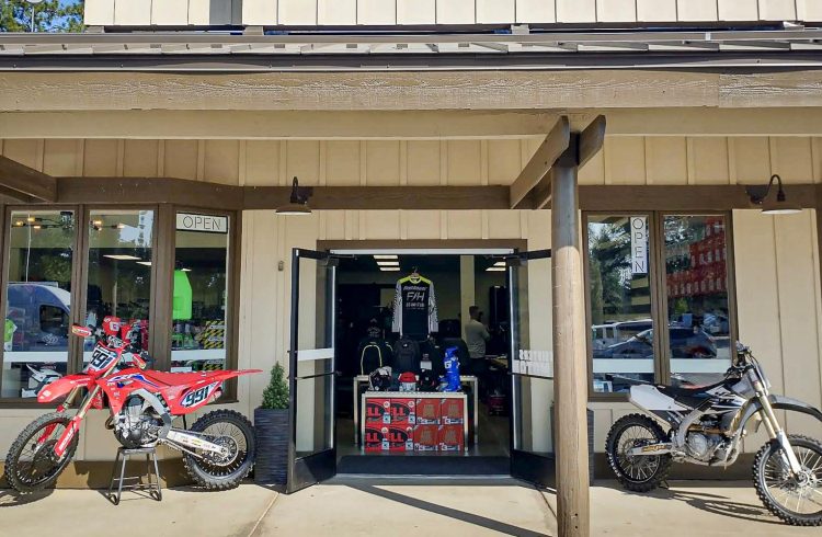 front entrance of a motorcycle shop with two bikes flanking the doorway