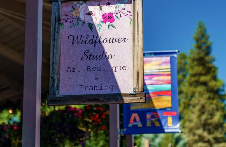 wildflower studio sign with blue sky and tree in the background