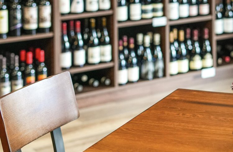 small table in a wine shop with wine on shelves in the background