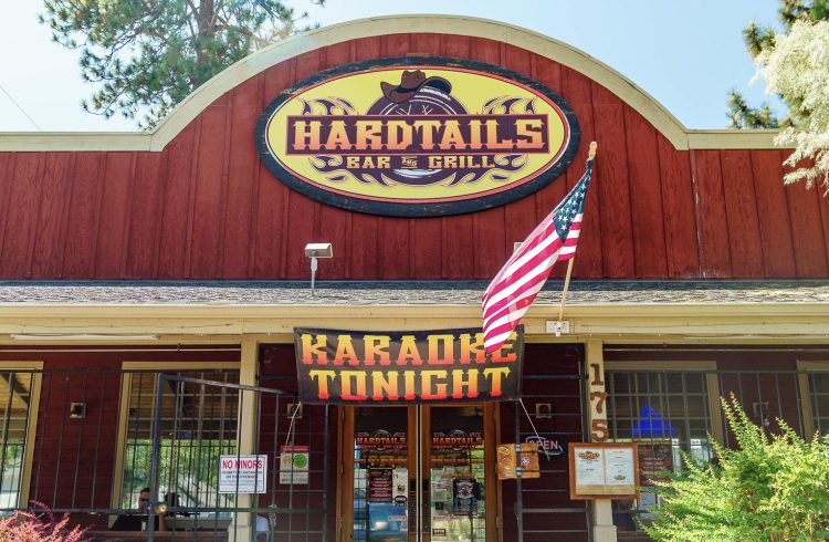 front door at hardtails bar with landscaping and an American Flag
